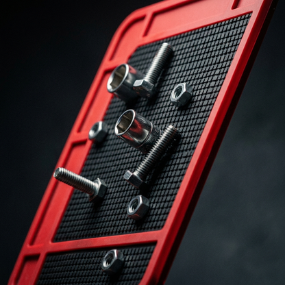 Close-up of bolts and a socket clinging to the magnetic mat surface at an angle